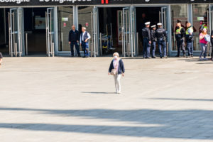 Frau mit Mundschutz läuft über den Bahnhofsvorplatz in Köln Frau mit Mundschutz läuft über den Bahnhofsvorplatz in Köln